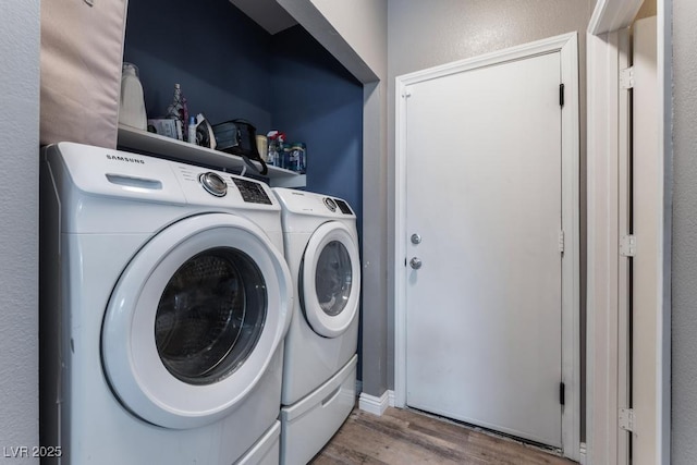 laundry room with wood finished floors, washing machine and dryer, and laundry area