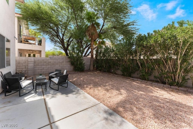 view of patio with a balcony and a fenced backyard