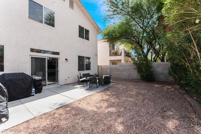 back of property with a patio area, an outdoor hangout area, fence, and stucco siding