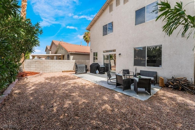 rear view of property with stucco siding, a patio, and fence