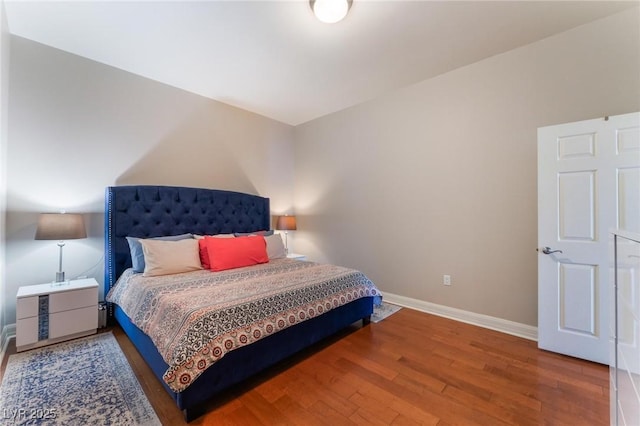 bedroom with baseboards and wood finished floors