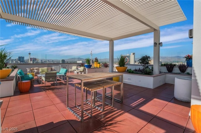 view of patio / terrace featuring outdoor dining space, a city view, and a pergola