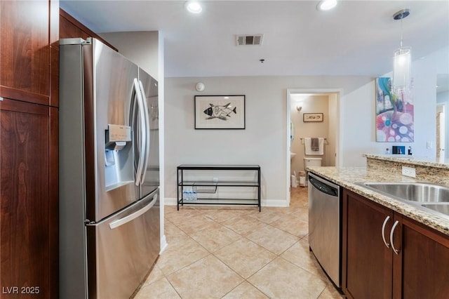 kitchen featuring visible vents, light stone countertops, hanging light fixtures, appliances with stainless steel finishes, and light tile patterned flooring