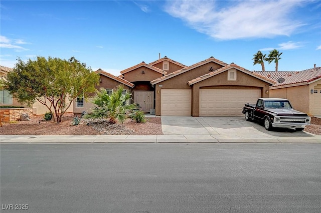 view of front of house featuring stucco siding, driveway, a tile roof, and a garage