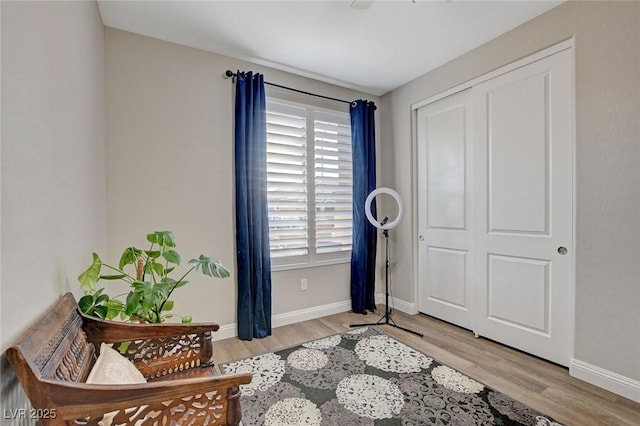 living area featuring baseboards and light wood-style floors