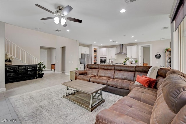 living room featuring recessed lighting, visible vents, light tile patterned flooring, and stairs