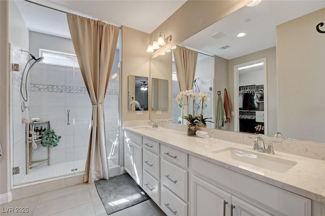 full bath featuring tile patterned floors, visible vents, a stall shower, a sink, and double vanity