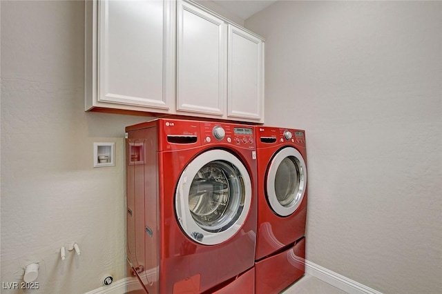 laundry area with washer and dryer, baseboards, cabinet space, and a textured wall