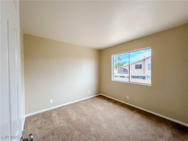 carpeted spare room with baseboards