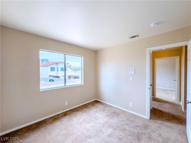 spare room with visible vents, baseboards, and carpet