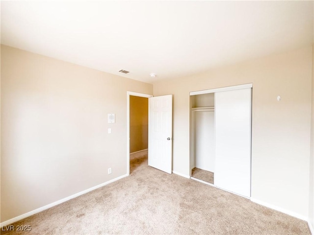 unfurnished bedroom with a closet, baseboards, visible vents, and carpet flooring