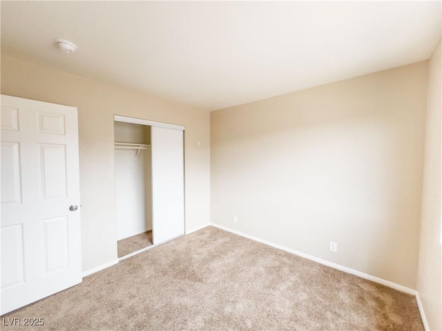 unfurnished bedroom featuring a closet, baseboards, and carpet flooring