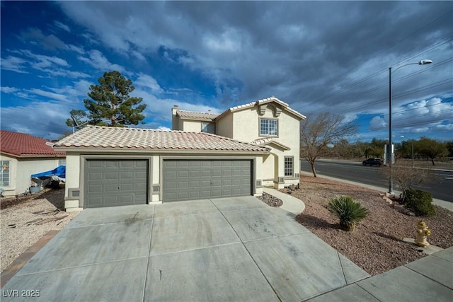 mediterranean / spanish-style house featuring a tile roof, stucco siding, concrete driveway, and a garage