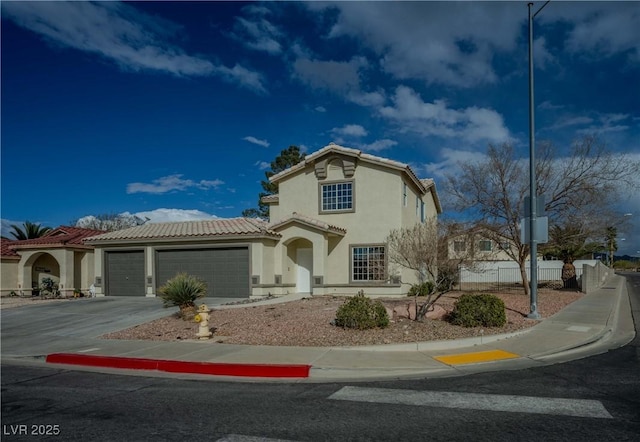 mediterranean / spanish-style home featuring stucco siding, driveway, a tile roof, fence, and an attached garage