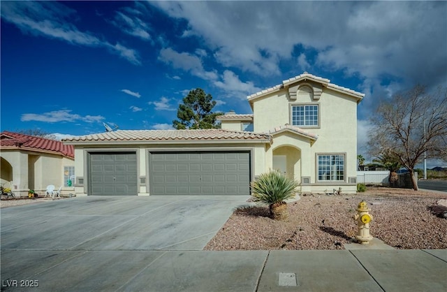 mediterranean / spanish-style home with a tiled roof, stucco siding, driveway, and an attached garage