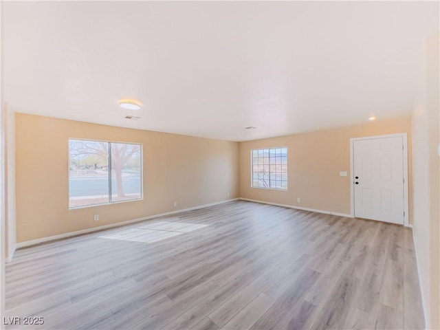 unfurnished living room with visible vents, light wood-style flooring, and baseboards