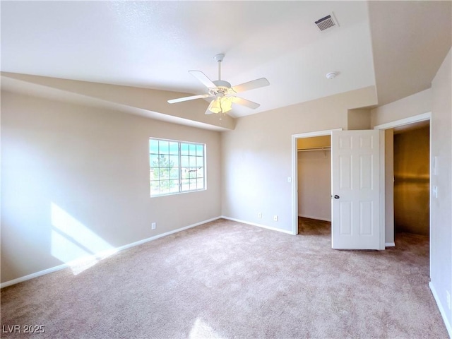 unfurnished bedroom featuring a spacious closet, carpet flooring, baseboards, and visible vents