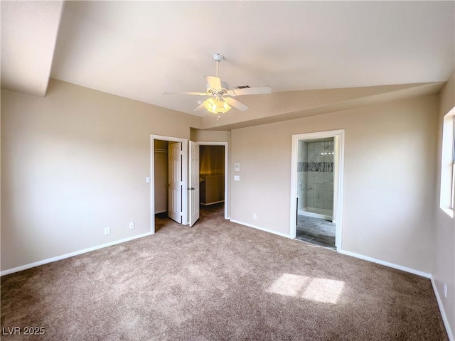 unfurnished bedroom featuring connected bathroom, a walk in closet, baseboards, and carpet floors