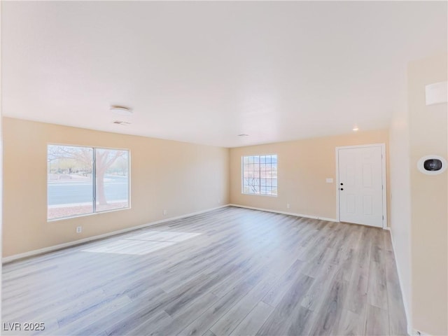 unfurnished room featuring light wood-style flooring and baseboards