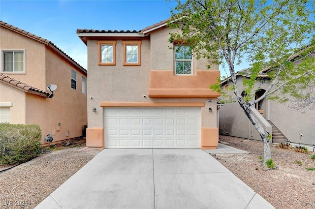 view of front of home featuring a tiled roof, stucco siding, driveway, and an attached garage