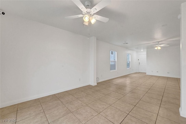 unfurnished room featuring baseboards, ceiling fan, and light tile patterned flooring