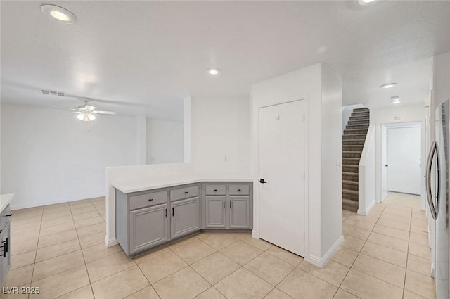 kitchen featuring light tile patterned floors, a ceiling fan, visible vents, and gray cabinetry