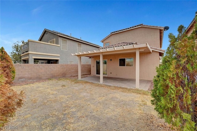 back of house with a tiled roof, fence, stucco siding, and a patio area