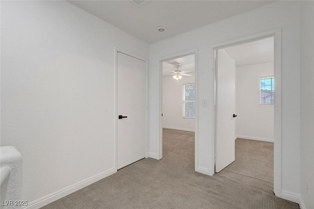 unfurnished room with a healthy amount of sunlight, baseboards, and light carpet