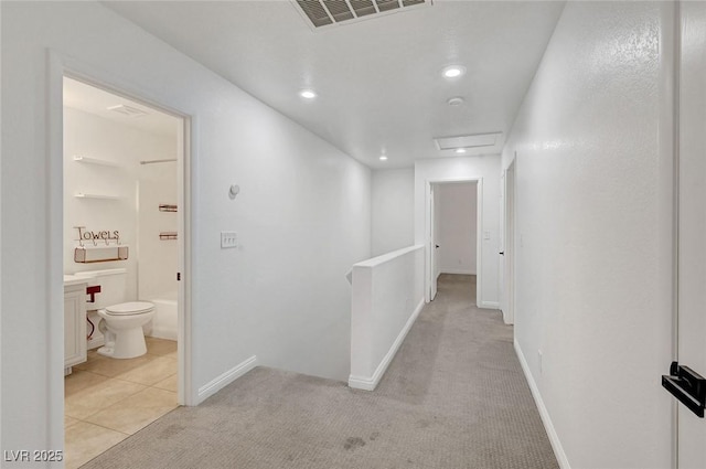 hall with visible vents, baseboards, light carpet, an upstairs landing, and recessed lighting