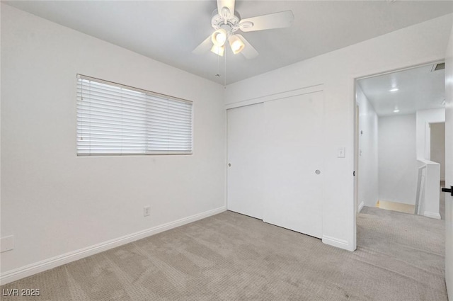 interior space featuring baseboards, attic access, ceiling fan, and carpet flooring