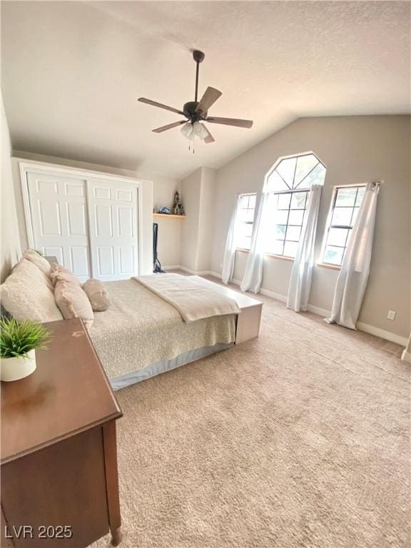 carpeted bedroom with lofted ceiling, a ceiling fan, baseboards, and a textured ceiling