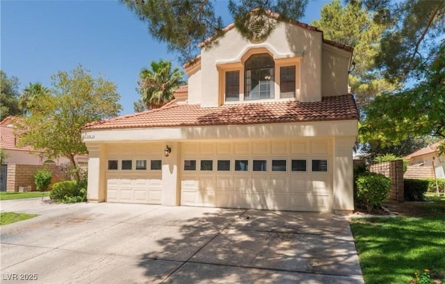 mediterranean / spanish-style house with stucco siding, driveway, and a tile roof