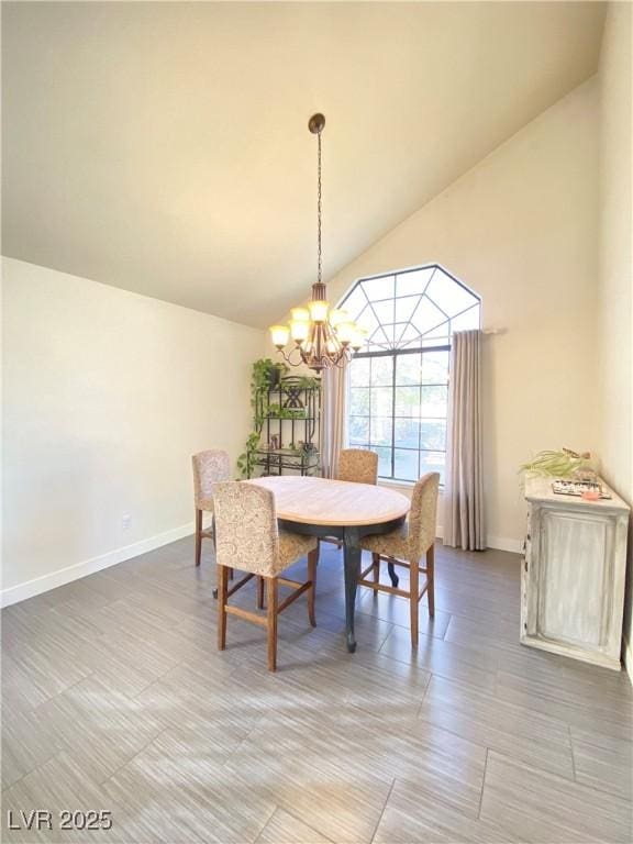 dining space featuring a chandelier, high vaulted ceiling, and baseboards