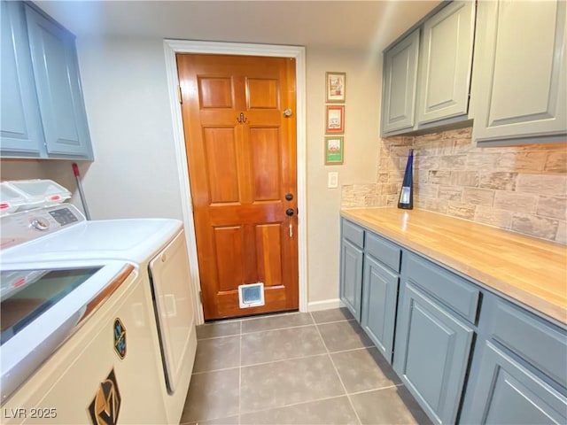 clothes washing area with light tile patterned floors, cabinet space, and independent washer and dryer