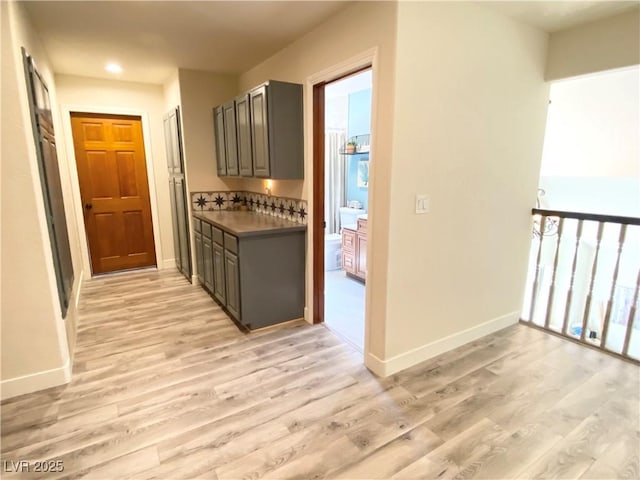 kitchen with baseboards, light wood finished floors, and gray cabinetry