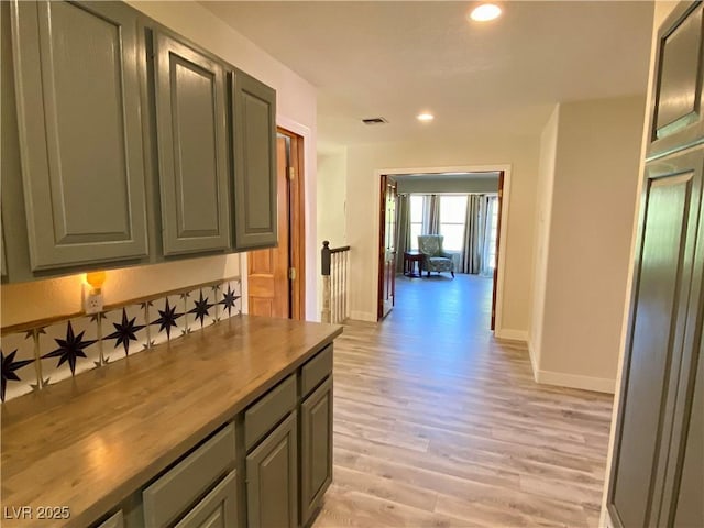 corridor featuring visible vents, baseboards, an upstairs landing, recessed lighting, and light wood-style flooring