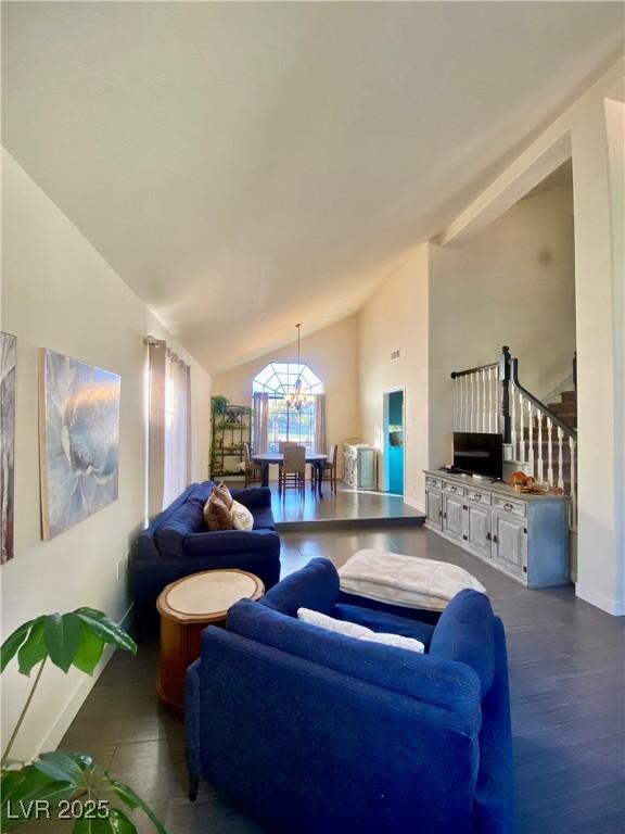 living room featuring baseboards, stairway, an inviting chandelier, wood finished floors, and high vaulted ceiling