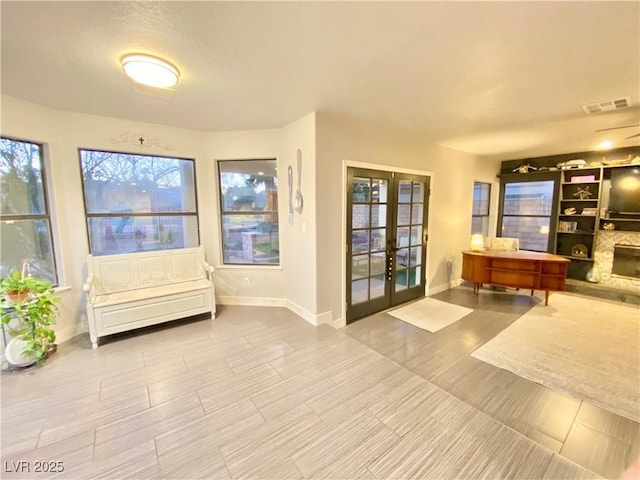 interior space with a wealth of natural light, french doors, and visible vents