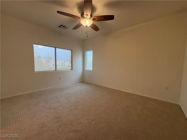 empty room with visible vents, light carpet, baseboards, and ceiling fan