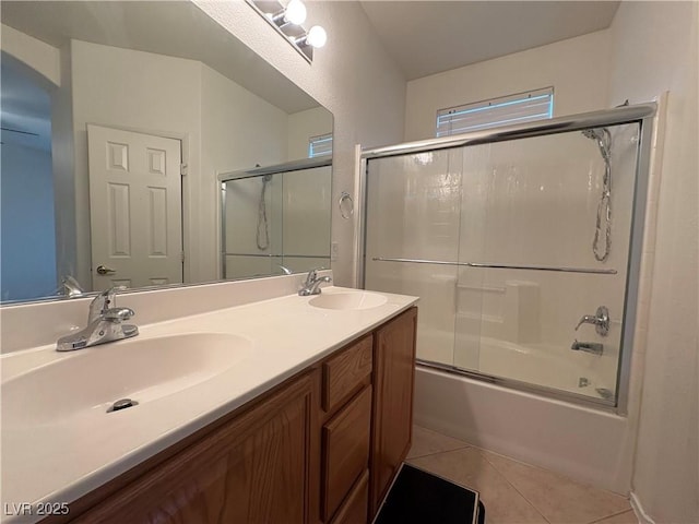 full bath featuring a sink, combined bath / shower with glass door, double vanity, and tile patterned floors