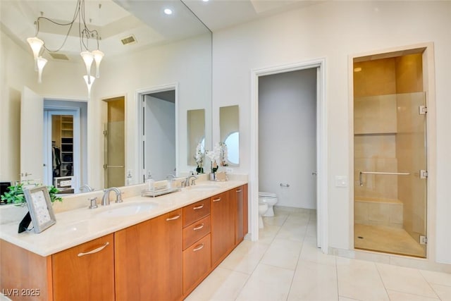 full bathroom featuring tile patterned floors, a sink, double vanity, toilet, and a shower stall