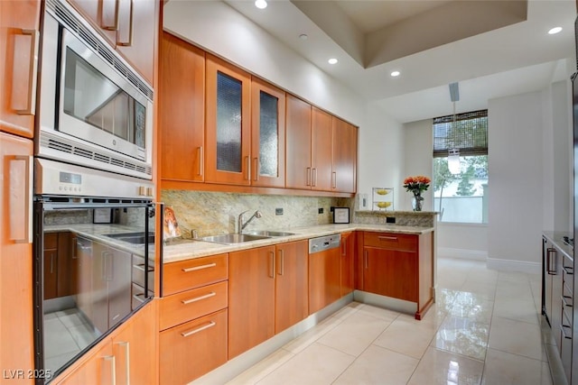 kitchen featuring a sink, baseboards, recessed lighting, decorative backsplash, and appliances with stainless steel finishes