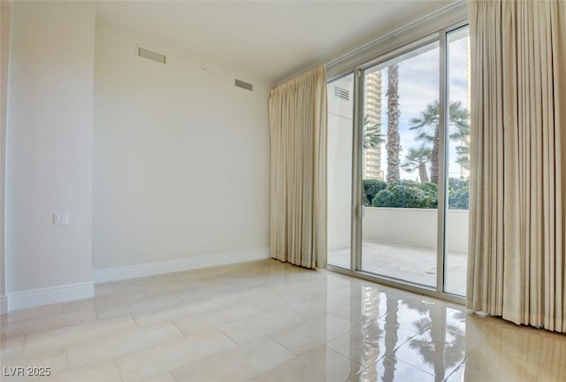 spare room with visible vents, plenty of natural light, and baseboards