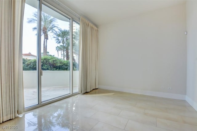 unfurnished room with tile patterned floors and baseboards