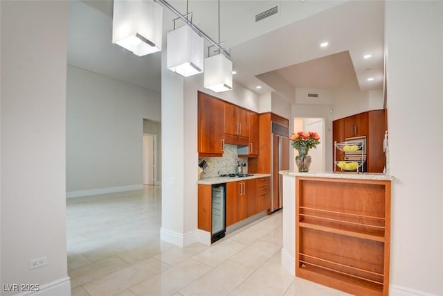 kitchen featuring brown cabinetry, stainless steel appliances, decorative backsplash, light countertops, and wine cooler