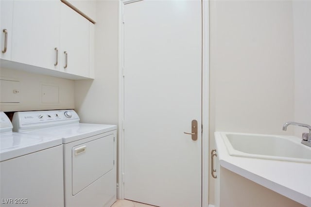 washroom with cabinet space, a sink, and separate washer and dryer