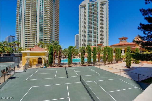 view of sport court with a city view and fence