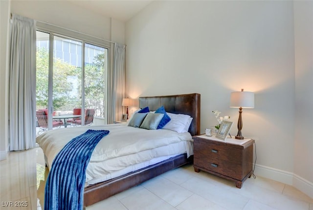 bedroom featuring access to outside, baseboards, multiple windows, and tile patterned floors
