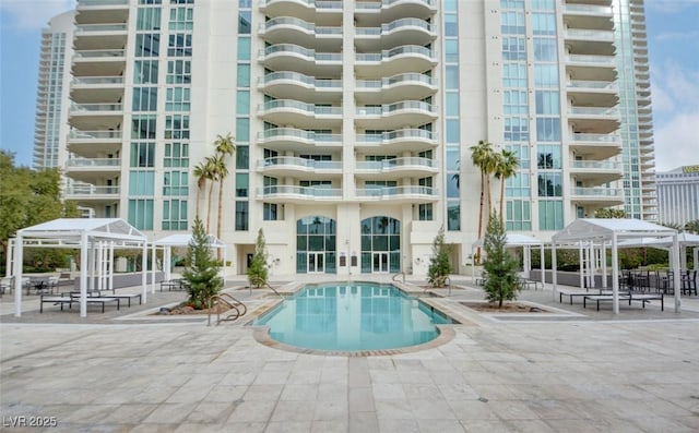 pool with a gazebo, a patio area, and french doors