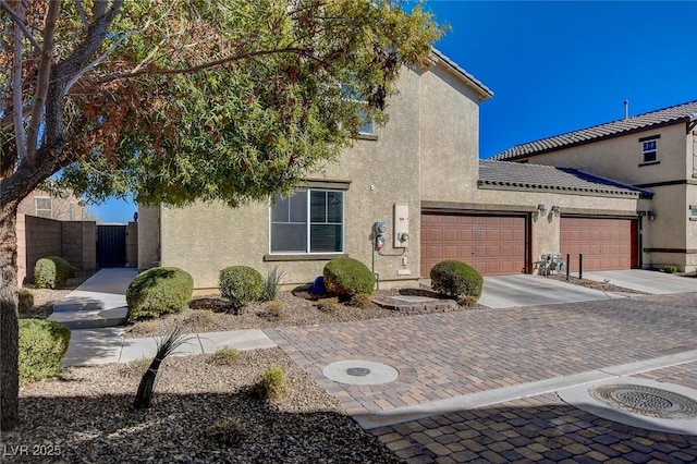 view of front of property with stucco siding, a garage, and fence